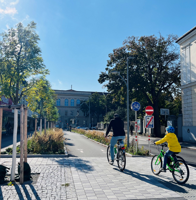 Baulich getrennter Radweg, Mann und Kind fahren Rad