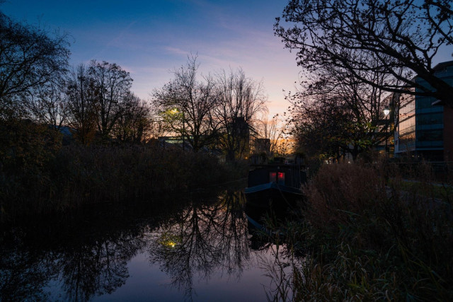 A canal boat amongst the reeds at dusk