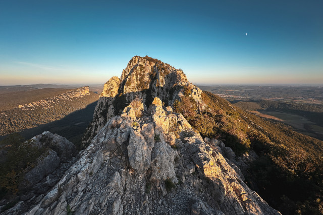 Un “chemin” de crête sur le pic saint loup, roches abruptes, on voit le massif de l’Hortus à gauche