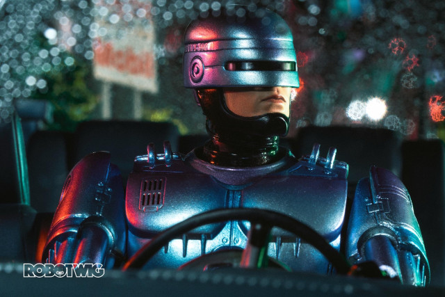 Robocop driving around rainy night headlights in background 