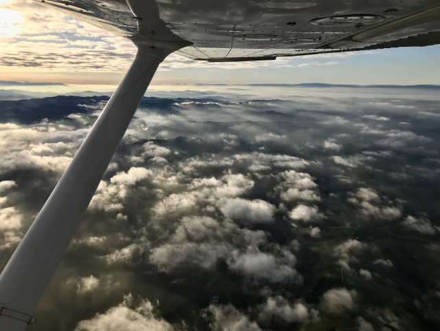 Flying over puffy clouds in the evening.