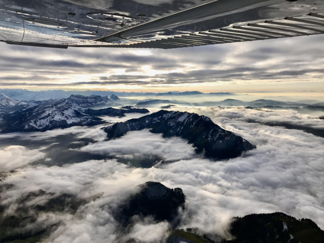 View on Swiss Alps with clouds between the mountain ridges.