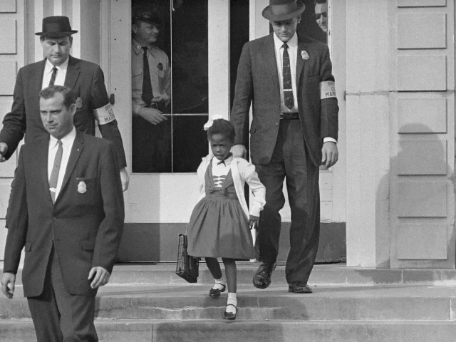 William Frantz Elementary School, New Orleans, 1960. "After a Federal court ordered the desegregation of schools in the South, U.S. Marshals escorted a young Black girl, Ruby Bridges, to school."

Uncredited DOJ photographer, restored by Adam Cuerden (a relatively minor restoration)

