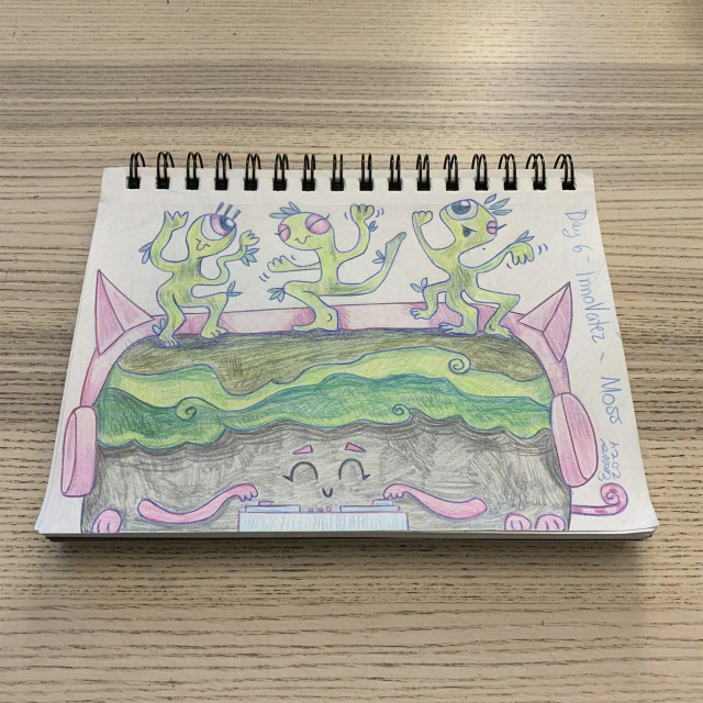 sketchbook resting on a pale wooden surface. sketch of three smiling green critters with pink eyes dancing on a big rock. the mossy rock has pink cat headphones on, a pink striped tail, three pink paws, and two pink arms. they are smiling and playing music on a DJ table. the words "Day 6 - InnoVatez - Moss" are on the right side, along with a signature and date.