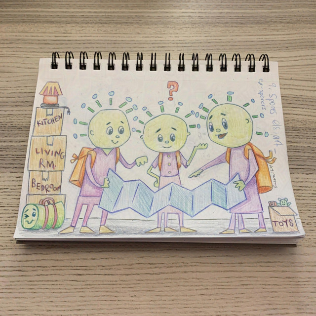 sketchbook resting on a pale wooden surface. drawing of three figures, the left and right one are holding a large map. they are all looking at the map. the right one is gesturing, the middle one looks confused and has a question mark, and the right one is pointing. they all have round heads with green floating hair, orange backpacks, purple shirts, pink pants, tan shoes, and green skin. there are moving boxes on the left and right. there is a lamp on the boxes on the right. there is a green duffle, smiling and winking on the left. on the right there is a signature and date as well as "9 Spores elsiart_" and "ex-sporers."