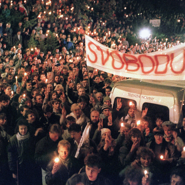 Students making victory signs and lighting candles in support of Vaclav Havel's presidency during a protest rally in Albertov quarter in Prague. On the banner on the right is written:
 "Liberty"   