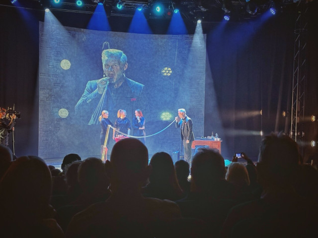 Photo of a stage with illusionist Henrik Fexeus and guests from the audience on stage.