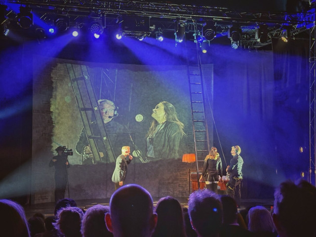 Photo of a stage with illusionist Henrik Fexeus and guests from the audience on stage.