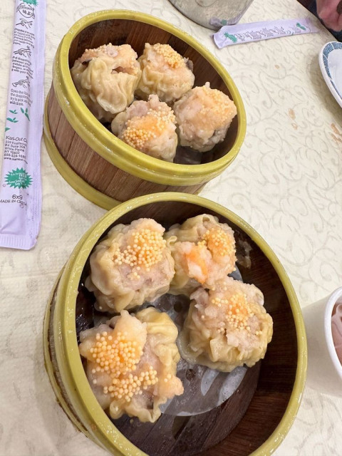 Two steamer baskets. Each with four delicious shumai. 