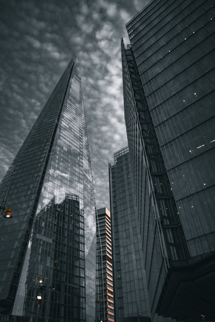 An image depicting the Shard, a prominent skyscraper in the heart of London, amidst a backdrop of wispy clouds.