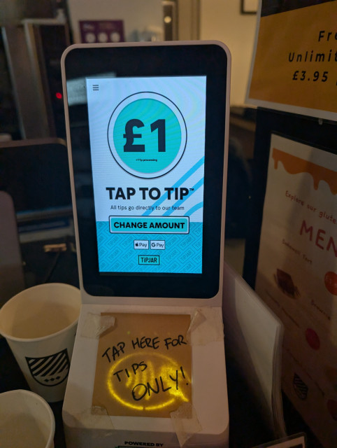 A TIPJAR PoS payment processing unit with a post-it reading TAP HERE FOR TIPS ONLY!