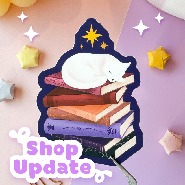 A photo of a sticker of a white cat sleeping on top of a stack of books outlined in a deep blue.