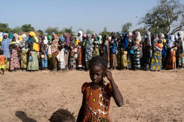 Women wait for food distributed by a local aid group at a camp outside Ouagadougou, capital of Burkina Faso. More than 2 million people in the country are estimated to be exposed to the conflict. Photograph: Emre Çaylak 

