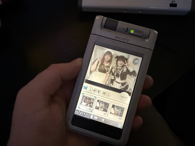 A Sony Clie NX70V running the Clie Camera app with a photo on the screen. There are buttons for info, delete, send etc