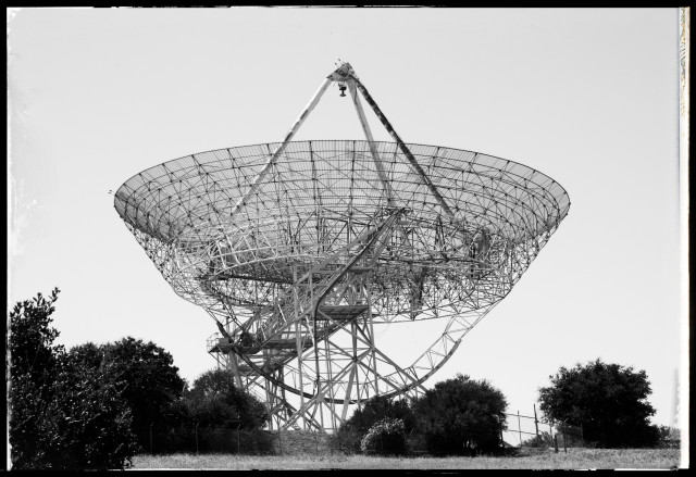 A monochrome photo of the Stanford Dish: a giant, upward-pointing, 150-in-diameter radio antenna set against bright gray skies.

The mesh steel dish is a familiar sight to people driving Interstate 280 through the rolling, grass and tree-lined hills behind Stanford University. 

Wikipedia says the dish was once used for detecting Soviet radar installations by monitoring signals bounced off the moon. Later, it was used for satellite communications... and now is used for "academic and research purposes." No spooky, hidden spy stuff there, right?