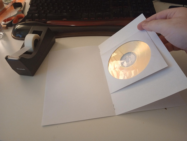 a booklet made of two 8.5x11 inch pages stapled together and folded in half, for an overall size of 8.5x5.5 inch. in the middle of the booklet is a CD disc in a paper sleeve. The disc is only 5 inches wide so it fits inside the booklet.