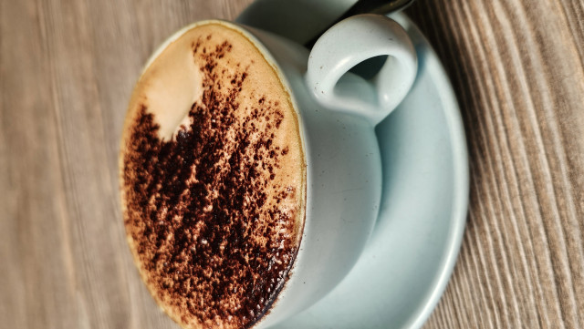 Cappuccino mit Milchschaum und Schokopulver auf dem Schaum, ein Löffel vom Schaum wurde schon probiert, den Kakao mag ich nämlich nicht im Cappuccino