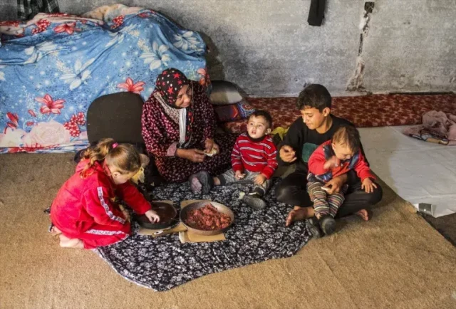 Children sharing a meal with their grandmother.