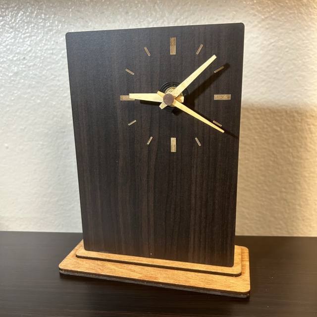 Monolith clock in walnut panel with wood hands seen 3/4 view right