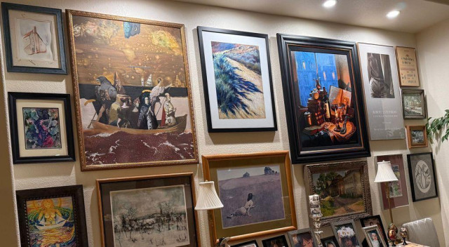 A gallery wall with 15 paintings/prints. Beautifully curated and lighted. 