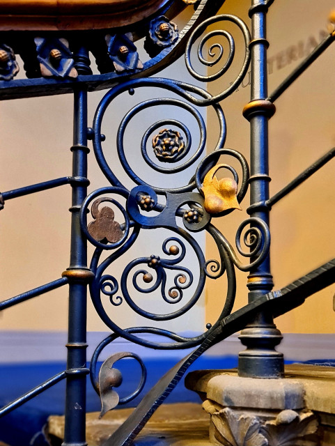 Sinuois wrought iron metalwork on the ballastrade of a staircase.