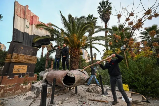 a man jumps on top of a knocked over statue with no head