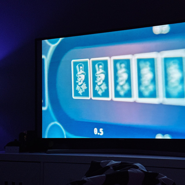 A scene from the film, online poker table with 5 cards that have skulls in them