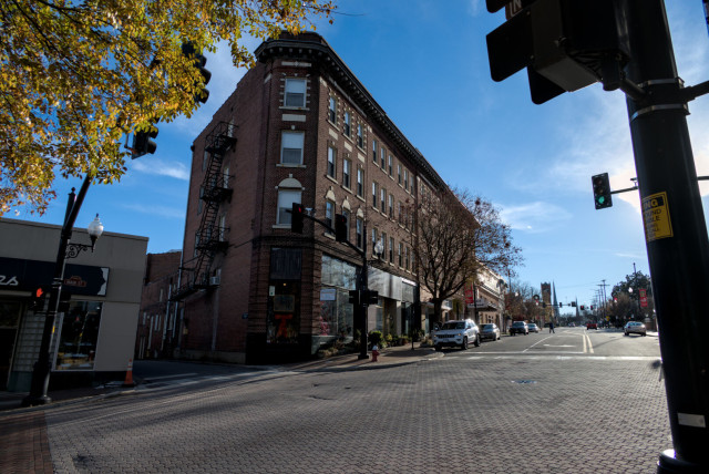 A broad brick flattiron building at the corner of Floyd St. The roof points at the lower right corner of the photo past the street.