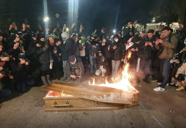 Protestors in Tbilisi, Georgia gather round a burning coffin containing an effigy of Bidzina Ivanishvili.