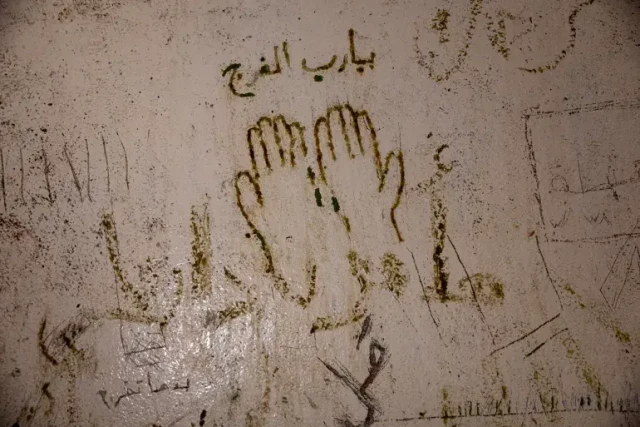 [Ugur Yildirim/ dia images via Getty Images]
Drawings and writings etched by prisoners walls of the infamous Mezzeh Prison in Damascus