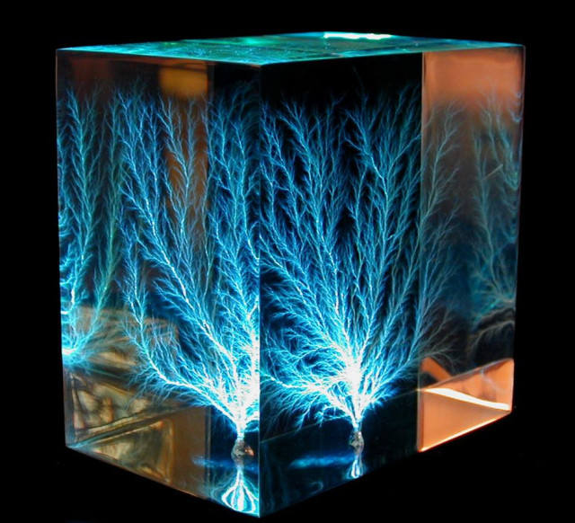 Modern 3D Lichtenberg figures or "electrical treeing" in a block of clear acrylic, created by irradiating the block with an electron beam. Actual size: 80 mm × 80 mm × 50 mm (3 in × 3 in × 2 in)