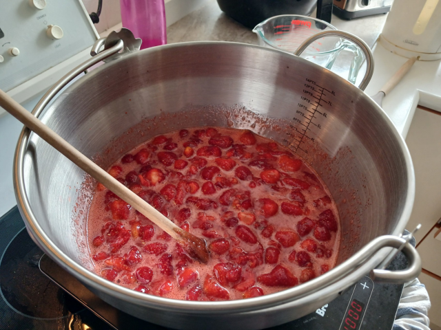 Strawberries bubbling away in a preserving pan.