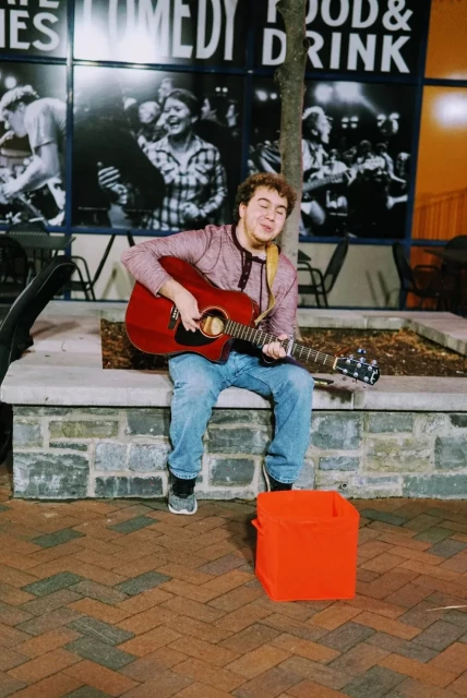 A man busking with a guitar