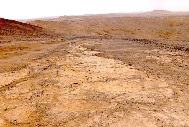 A photography of a Martian landscape, captured by the Perseverance rover on the west side of the rim of Jezero Crater.