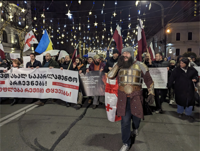 Historians on the right side of history march in Tbilisi Georgia, led by a man in a traditional Georgian knight costume.