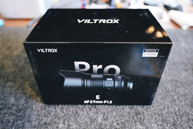 Viltrox 27mm F/1.2 G Pro box. It's black with the lens prominently in the center behind it it reads "Pro".