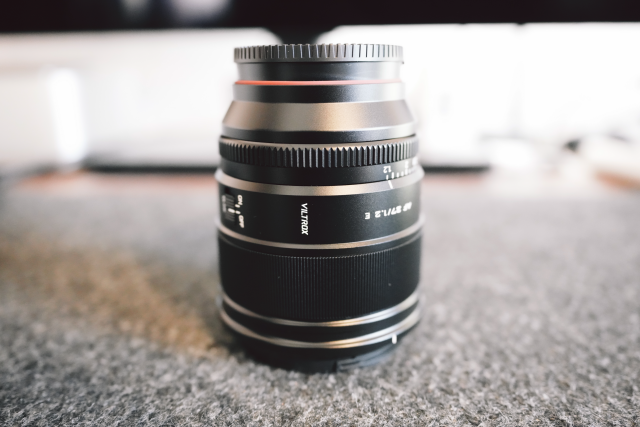 The Viltrox 27mm F/1.2 lens on a desk.