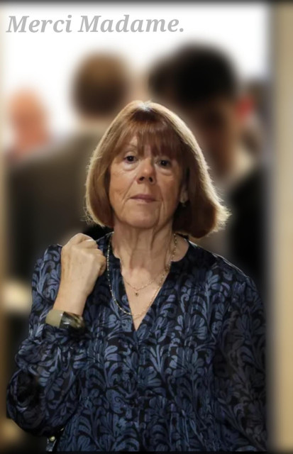 Photography. A portrait photo of Gisèle Pelicot and the text: "Merci Madame". The photo shows an older woman with a wrinkled face, wearing her short reddish hair in a pageboy cut. She is wearing a blue and black patterned blouse and is standing in front of a door to a courtroom where several men are standing. Her hand is clenched into a fist, but she doesn't look threatening, she looks brave. She looks into the camera. 
Info: 71-year-old French woman Gisèle Pelicot was drugged by her husband for years and offered sex to countless men. She herself knew nothing about it and was only informed by the police. The trial against her husband and 50 rape victims has attracted a lot of attention, partly because she does not want to be a victim, because it is not she who should be ashamed, but the cowardly perpetrators. The verdict in this exhausting trial was announced today and Madame Pelicot has given many women the strength not to give up and to fight back. Thank you, Madame.
