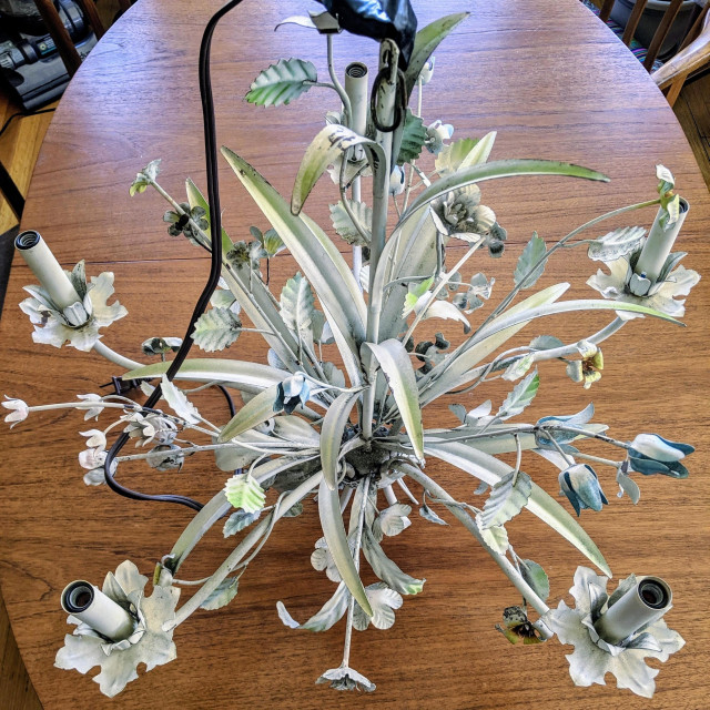 "Before" photograph of the vintage tole chandelier. It's painted white with accents of color on some of the leaves and flowers. The paint is chipped and grey from accumulated dust. Photograph CC BY-SA Kate Zimmerman.