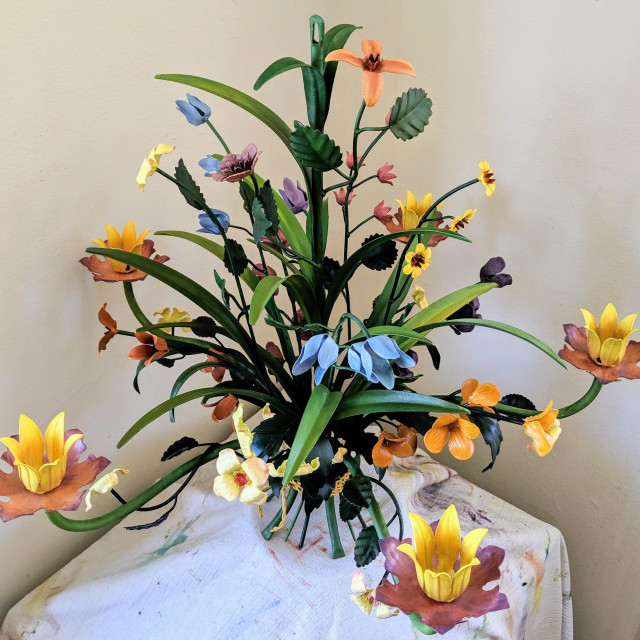 "After" photograph of the vintage tole chandelier. The leaves and stems are painted in varying shades of green, the flowers range from yellow to orange to pink to purple to blue. CC BY-SA Kate Zimmerman.