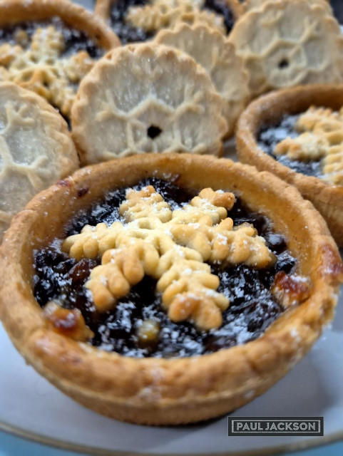 Close up on a festive mince pie with more in the background.

From its humble beginnings as a savory Christmas pie centuries ago, the modern mince pie has transformed into a beloved sweet treat. Served hot or cold, often with thick whipped cream or ice cream. imagine a golden, buttery, crumbly pastry shell cradling a warm, fragrant mix of dried fruits, aromatic spices.