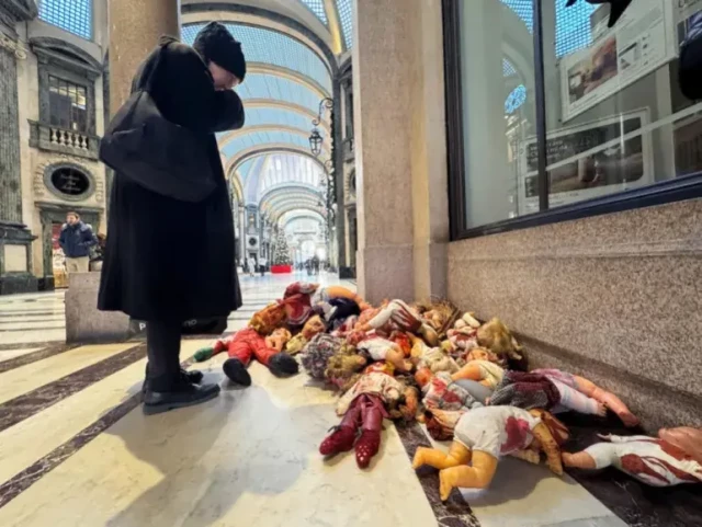 A woman looks at dolls piled up in the San Federico Gallery in Turin, Italy, during a protest by pro-Palestinian activists against Israel’s killing of civilians in the Gaza Strip, on Thursday [Alessandro Di Marco/EPA]