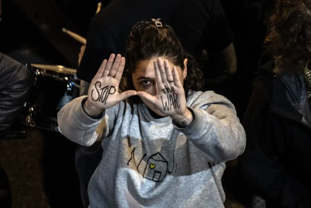 A woman shows a message on her hands reading ‘stop the war’ 