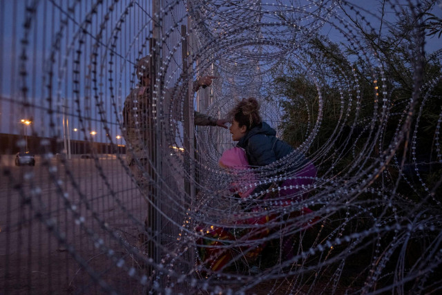 The woman caught - literally - in rolls of razor wire at the U.S.-Mexican border in this photo gave her name as Eliana, a 22-year-old Venezuelan who was attempting to cross with her two young daughters into Texas in March.

Photographer Adrees Latif met her as she hid with some migrants while others cut a hole in the fence.

“After weeks of traveling north from her home country of Venezuela, the opportunity she awaited was only moments away,” said Latif. “Her aim was to make a 100-meter dash past the razor-wire fence, without being stopped by Army soldiers and state troopers, towards the border wall, where she would be allowed to surrender to immigration officials.”

Once a space was cleared, the migrants began running through. Eliana’s six-year-old daughter Ariana crossed with another Venezuelan migrant. Right behind her was Eliana, carrying three-year-old Chrismarlees.

Then she got snagged on the wire.

At the moment of the photo, she is trying to push through, but a U.S. National Guard soldier has arrived and is telling the migrants to return.

Eliana backed away, said Latif. Nursing cuts from the wire, she huddled with the remaining migrants - and said she would seek to return.

Reuters was unable to determine what happened to Eliana or her daughters after the incident. The U.S. Customs and Border Protection agency declined to comment.