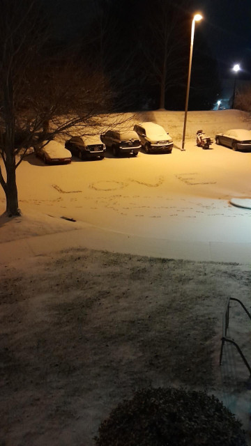 Snow covered parking lot with the word love in the snow