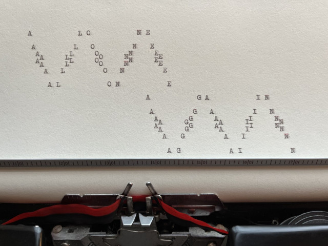 A page still in the typewriter with letters going up and down the page almost like a wave reading: “ALONE AGAIN”