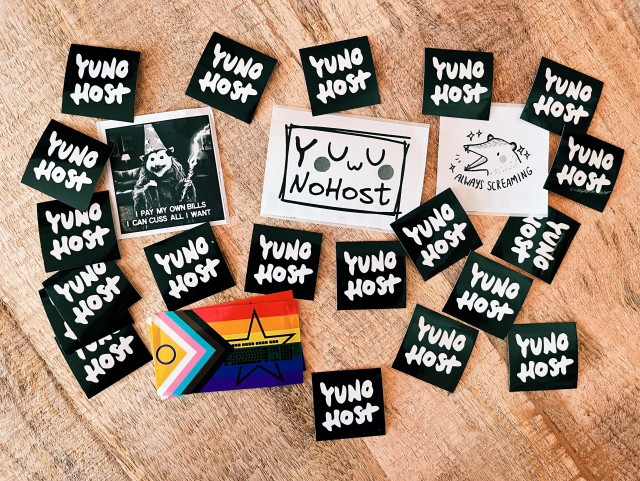 a photo of the stickers A. gave me as a present. It's a bunch of YunoHost stickers (black background, white logo) on a wooden table, along with an LGBTQIA+ support sticker, one with a raccoon dressed as a magician that reads "I pay my own bills I can cuss all I want" and a badger (I think) with the text "always screaming"