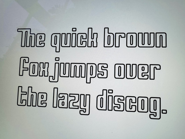 “The quick brown fox jumps over the lazy discog.” written in a typeface based on the Compact Disc logo.