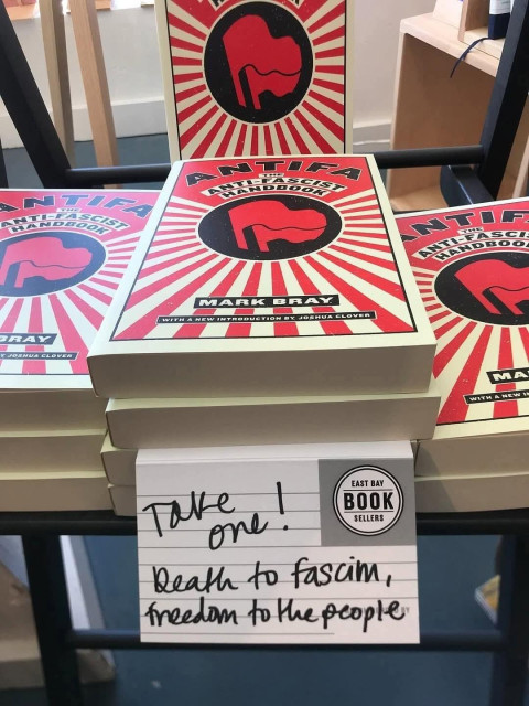 A table at the East Bay Booksellers, showing piles of Mark Bray's book, Antifa: the anti-fascist handbook.

A sign on the table says:
TAKE ONE!
DEATH TO FASCISM,
FREEDOM TO THE PEOPLE