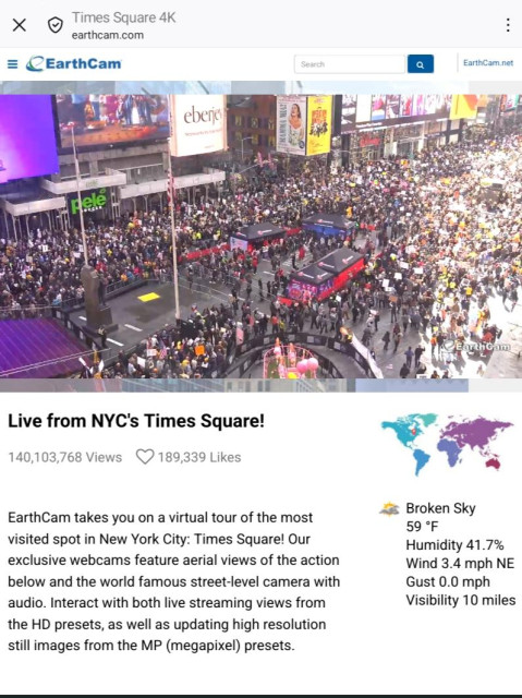 Earthca, trained on one of the 42nd Street exits to the subway, facing north on Broadway. we can see people with placards filling up the sidewalk  on the west side of the street while pedestrian traffic flows on the east sidewalk into the part of Broadway blocked to traffic acting now as a staging area for the march.